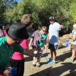 Rebekah finishes 1 mile fun run, Clint gives instructions for bib number and Tim presents finisher ribbon.